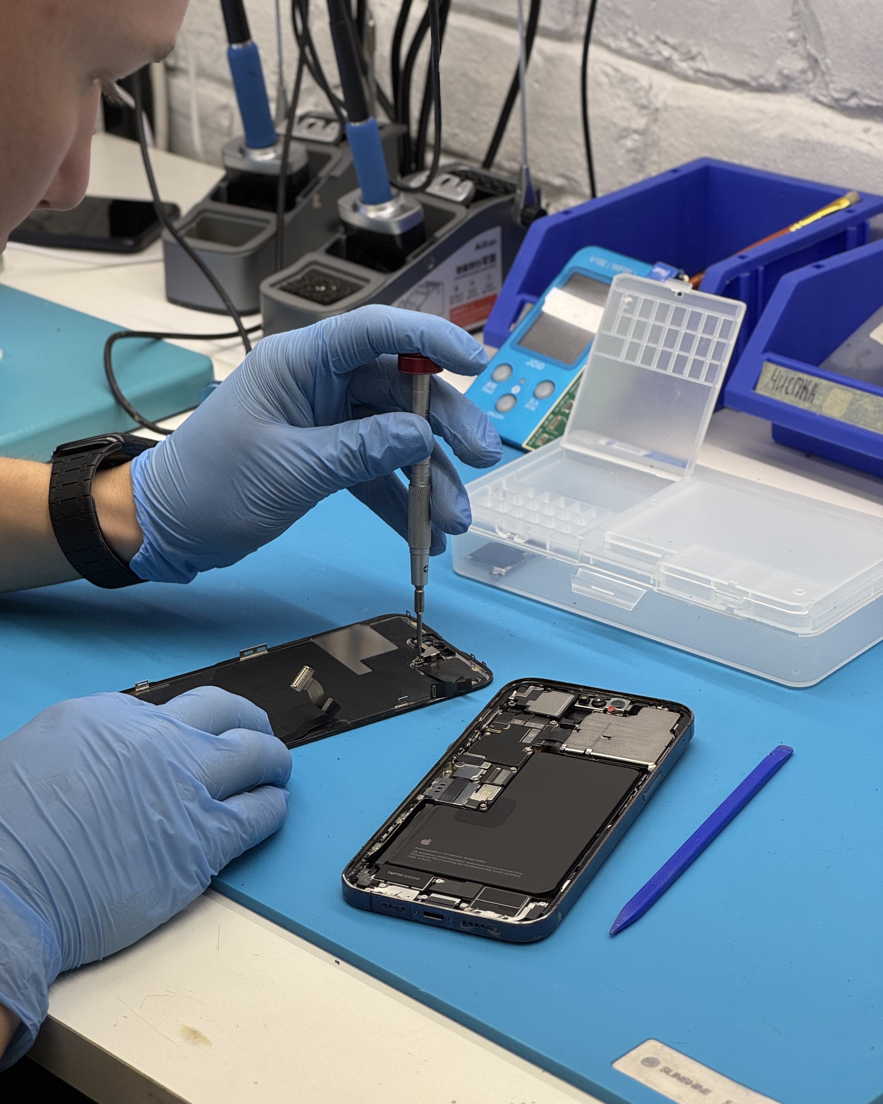 Мастер разбирает iPhone на рабочем столе
